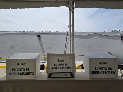 tres diferentes mamparas de votación sobre una mesa