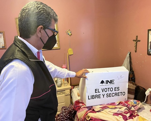 funcionario del INE en Baja California ayudando a una persona en estado de postración