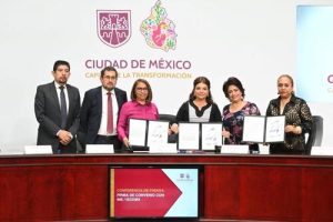 varias personas de pie mostrando una convenio firmado