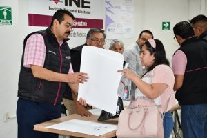 Presidente del Consejo Local del INE en el Estado de México entregando sobre blanco