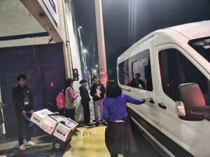 personas a un lado de una combi blanca