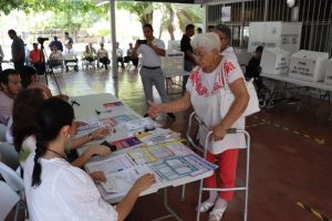 Mujer adulta mayor con andadera, en jercicio de Demostración de Votación con Enfoque de Accesibilidad en Colima