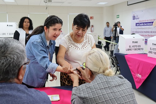 mujeres recibiendo tinta indeleble en el dedo pulgar