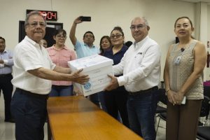 Presidente del INE en Campeche entregando a un hombre caja blanca