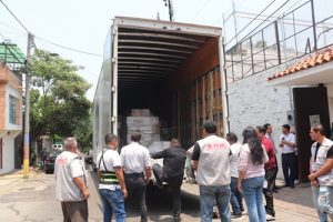 Funcionarios del INE Morelos descargando cajas de un camión