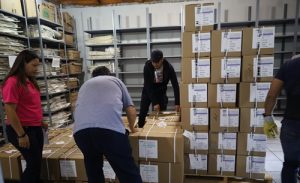 personal del INE Nuevo León acomodando cajas en Bodega