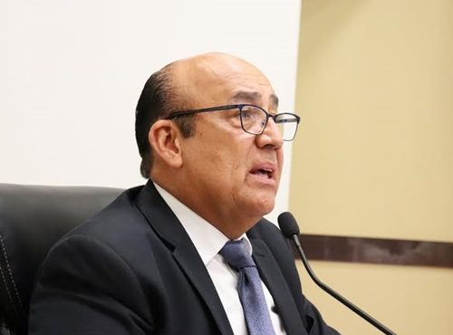 Hombre tez morena de lentes y calvo, hablando frente a un micrófono