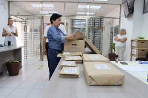 funcionaria del INE en Tabasco abriendo caja con paquetes electorales