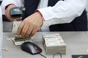 Persona usando una maquina lectora de códigos QR de la X Credencial para Votar