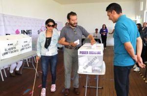 Mujer con debilidad visual siendo asistida por un familiar en casilla seccional en Tlaxcala