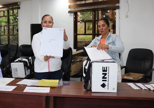 Funcionarias del INE Tlaxcala mostrando paquetería de Voto Anticipado