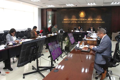 varias personas de consejo local sentados en salón de sesiones