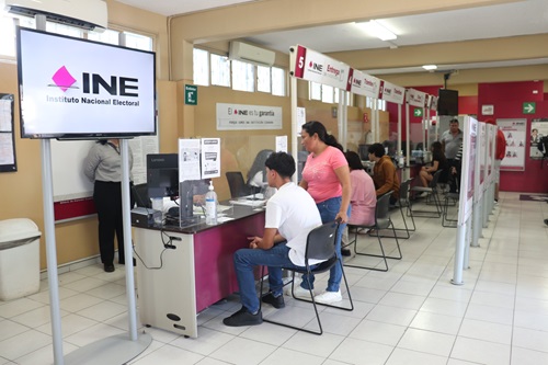dos personas frente a la ventanilla del módulo tramitando su credencial