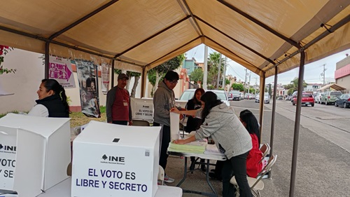 funcionarios de casillas atendiendo a las personas que acuden a votar
