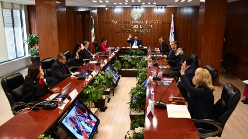integrantes del consejo local sentados en salón de sesiones y votando a mano alzada