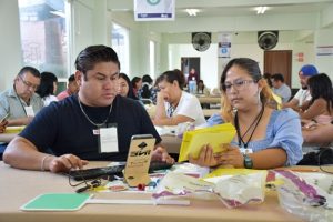 dos trabajadores del INE sentados realizando cómputos distritales