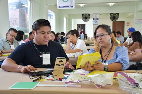 dos trabajadores del INE sentados realizando cómputos distritales