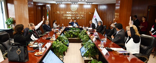 integrantes del consejo local sentados y votando a mano alzada