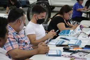 cinco personas sentadas en una mesa realizando cómputos distritales