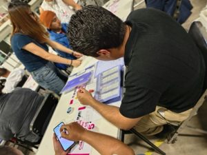 trabajador del INE lleva a cabo cómputo distrital en una mesa