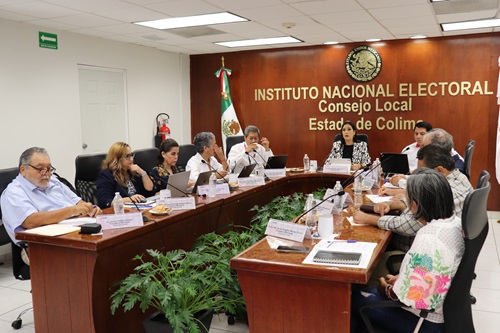 personas del consejo local sentados en salón de sesiones