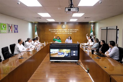 integrantes del consejo local sentados y votando a mano alzada