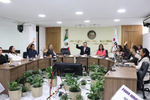 integrantes de consejo local sentados y votando a mano alzada