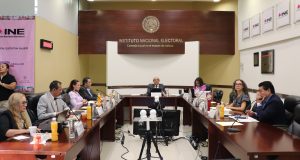 personas del consejo local sentados en salón de sesiones
