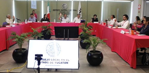 Miembros del consejo local sentados en el salón de sesiones laborando