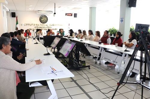 varias personas sentadas en salón de sesiones del consejo local