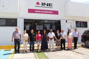 integrantes de consejo local de pie al exterior del INE colocando los resultados