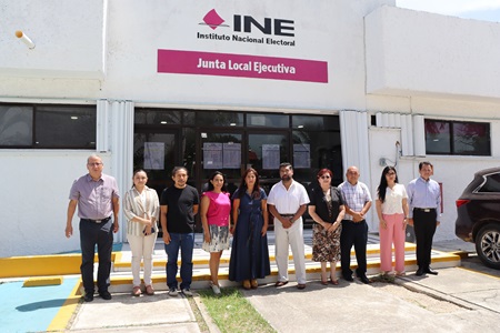 integrantes de consejo local de pie al exterior del INE colocando los resultados
