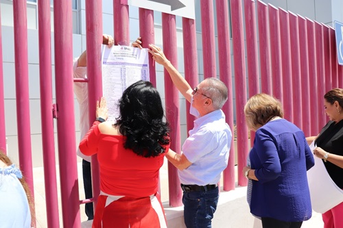 tres personas colocando los resultados al exterior del INE