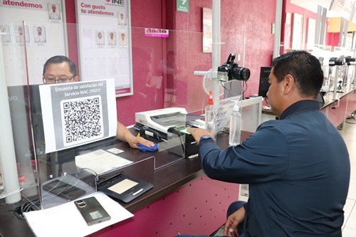 Una persona sentada en ventanilla de módulo tramitando su credencial