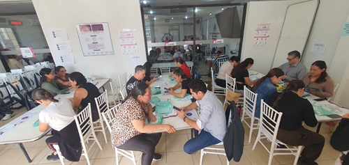 trabajadores del ine sentados realizando los cómputos distritales
