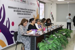 cinco personas sentadas en la mesa principal del seminario