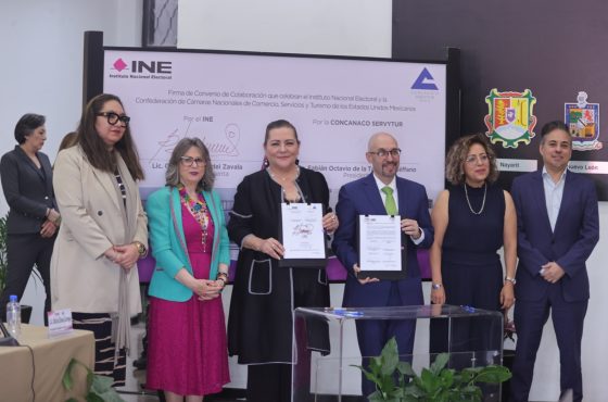 Participantes de la Firma de pie con el documento en las manos.