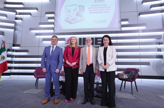 Personas participantes de la Mesa de análisis de pie al frente del auditorio.