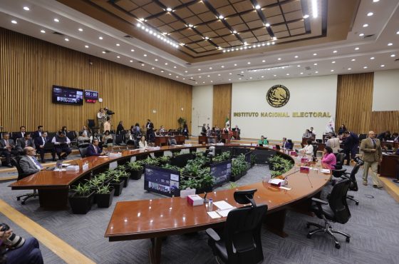 Salón de sesiones con el escudo de México al fondo con letras de color dorado que dice “Instituto Federal Electoral”, mesa en forma de herradura con 8 Consejeros Electorales y representantes de partidos políticos sentados; alrededor de la mesa directores ejecutivos, titulares de unidades técnicas y asesores.