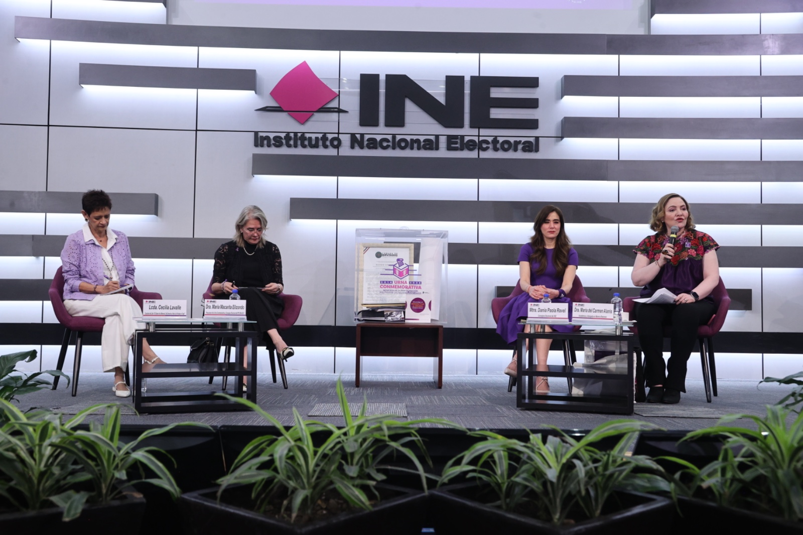 Imagen abierta en el auditorio del instituto con las personas participantes en el conversatorio 1 sentados en el estrado al frente del recinto y letrero del Instituto Nacional Electoral.