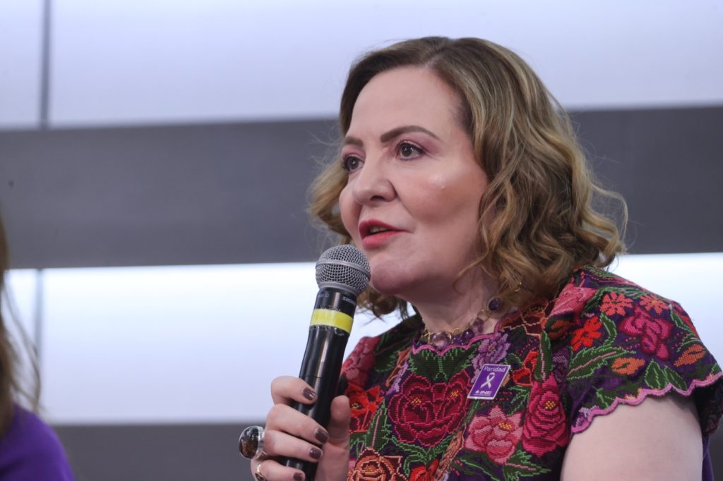 María Del Carmen Alanis Figueroa, Ex Secretaria Ejecutiva del  IFE, sentada hablando en el estrado al frente del recinto.