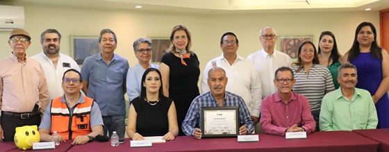 Varias personas unas de pie y otras sentadas mostrando un reconocimiento