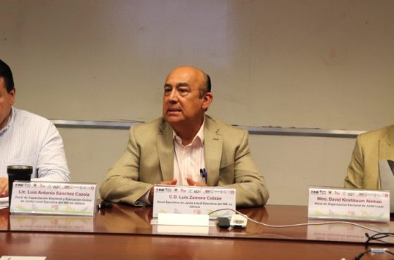 tres personas sentadas en una mesa dialogando con el resto de los presentes