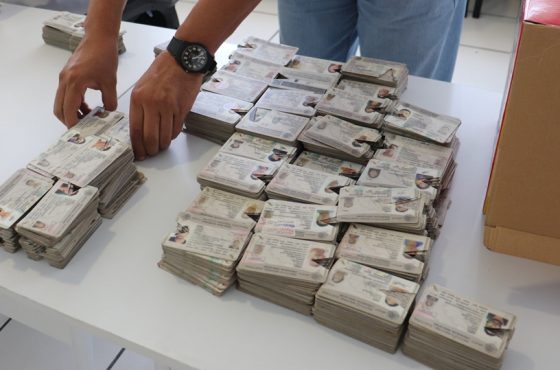 Varias credenciales para votar apiladas sobre una mesa para su posterior trituración