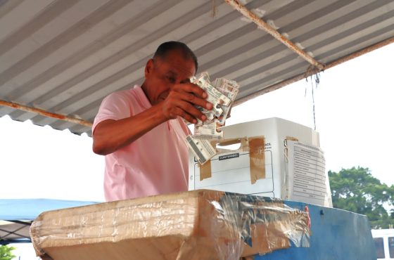 Una persona metiendo credenciales para votar destruidas en una caja blanca