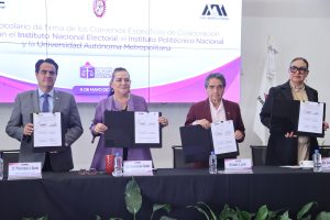 Participantes de la Firma de pie con el documento en las manos.