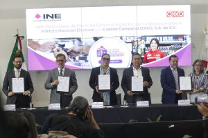 Participantes de la Firma de pie con el documento en las manos.