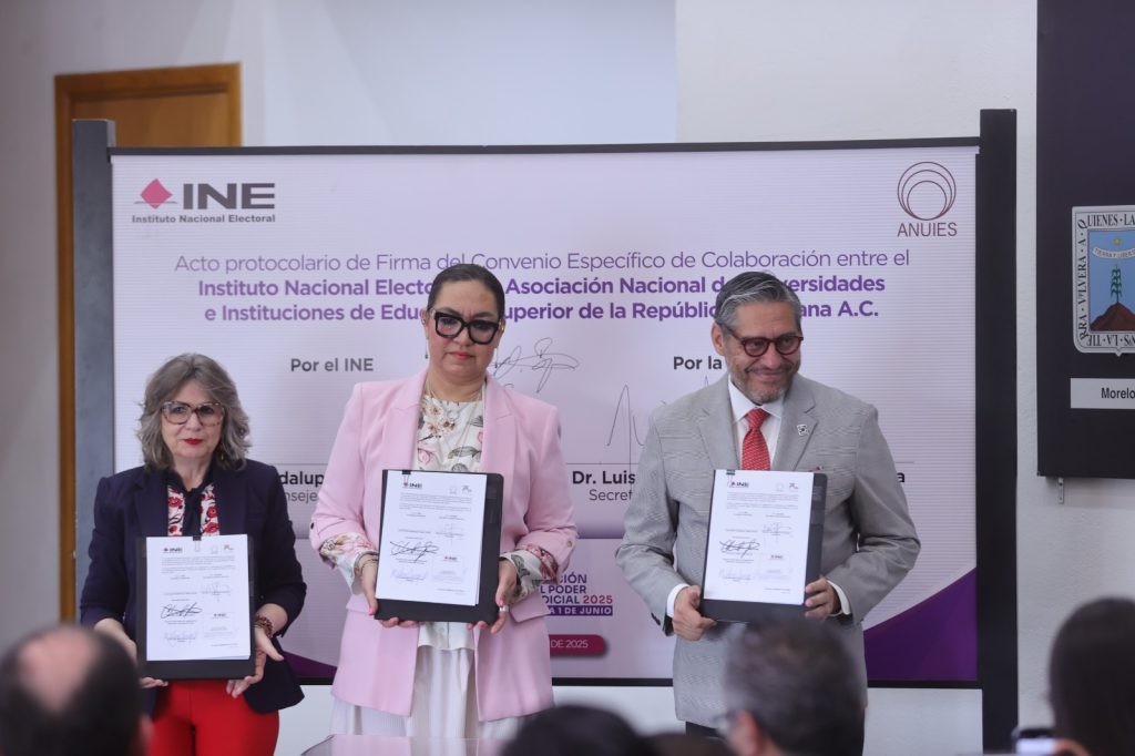 Participantes de la Firma de pie con el documento en las manos.