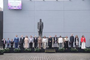 Personas consejeras electorales parados en la explanada frente a la estatua de Benito Juárez.