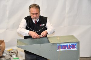 hombre metiendo credenciales para votar a una trituradora